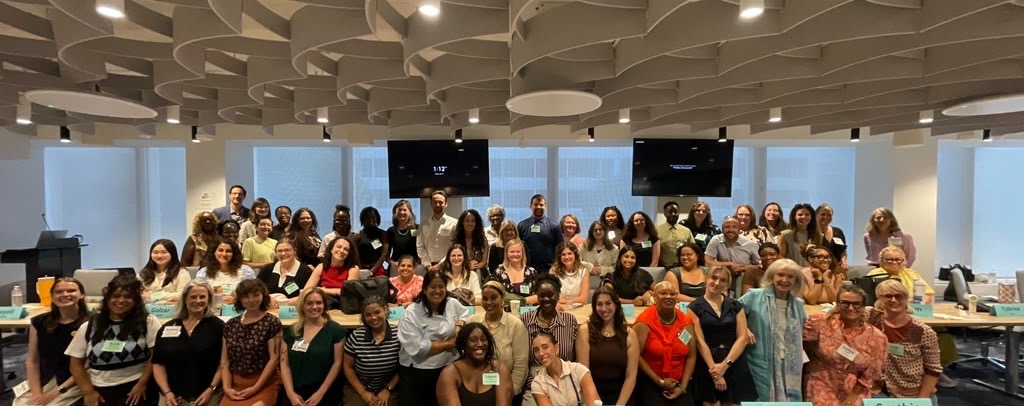 Participants stand in three rows facing the camera for a group photo.